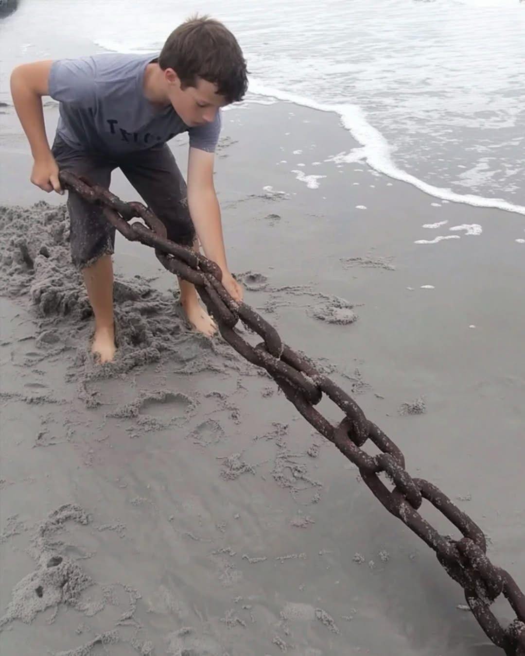 A Poor Boy’s Life Changes After He Pulls an Old, Rusty Chain Sticking Out of the Sand on a Remote Beach